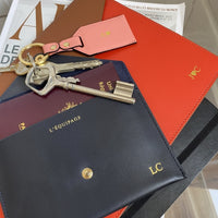 Assortiment de porte clés saumon et de deux enveloppes corail et noire