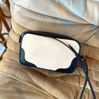 Caméra en cuir noir et toile blanche avec inscription L'Equipage