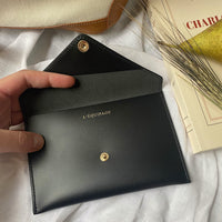 enveloppe noire ouverte avec inscription L'Equipage
